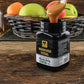 Offenes Glas Manuka Honig MGO 300 – ein Löffel Honig wird entnommen, im Hintergrund frische, gesunde Früchte